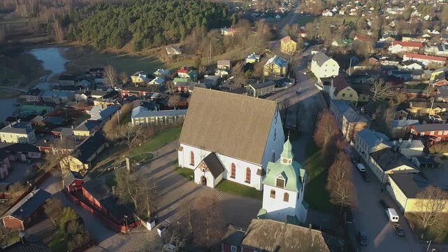Porvoo.Finland-December 12.2020: Closer aerial shot of the historical Evangelical Lutheran Church in Porvoo Finland with green forest in the background. Drone turning around the church.