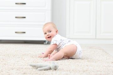 Fototapeta premium Cute little baby with toy crawling on floor at home