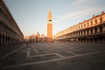 Naklejka premium Empty Saint Mark Square with the Campanile and Basilica in soft morning light in Venice, Italy. Colors: beige, blue, brown.