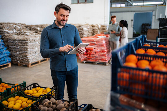 Man using tablet checking inventory in food warehouse