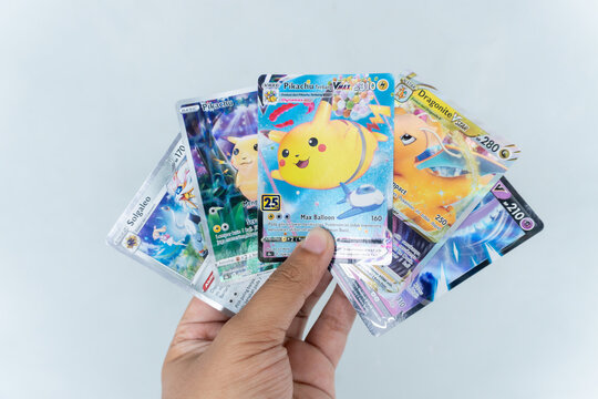 Banjar City, Indonesia: May 17, 2026: Pokemon cards held by a man's hand with a gray background
