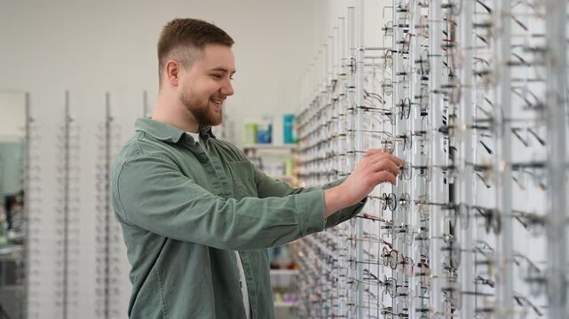 Young man choosing new stylish eyeglasses