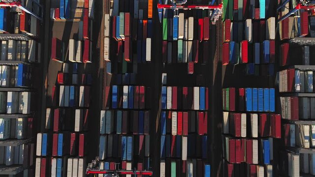 Abstract aerial pattern of stacked shipping containers and cargo cranes