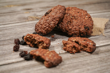 Fototapeta premium Sweet oatmeal cookie with brown sugar and raisins on vintage wooden table