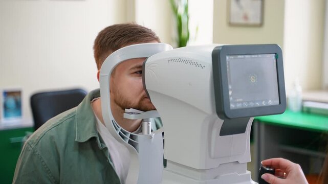 Young man undergoing eye examination with autorefractor