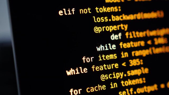 Python source code with syntax highlighting displayed on a dark monitor screen, showing while loops, class definitions, and torch import statements
