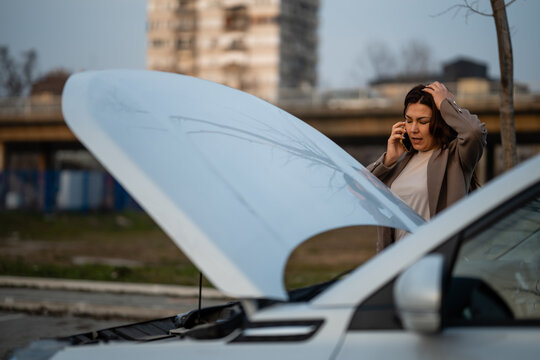 Woman experiencing car breakdown calling for roadside assistance