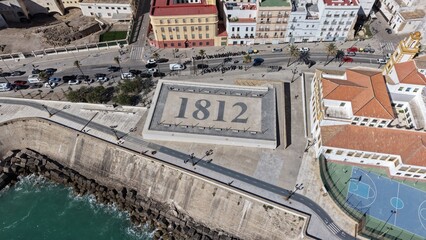 Aerial view of Cadiz Cathedral and its iconic golden dome by the sea. Cinematic drone shot of the historic landmark and the Atlantic Ocean coastline in Andalusia, Spain © Pablohasday