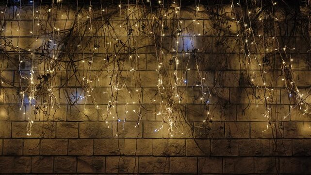 Christmas and New Year city lights illuminating a brick wall at night