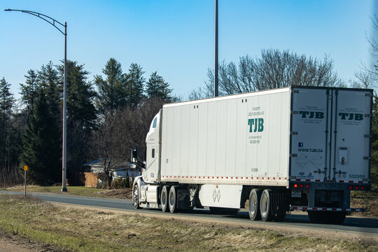 Quebec, Canada, 24 April 2026 : A white TJB Transport Jocelyn Bourdeau Inc. semi-truck with a trailer drives on a road.