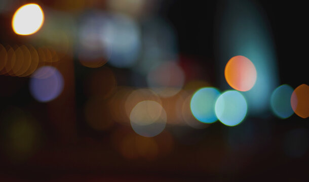 Teal orange white bokeh circle overlay on dark city night background