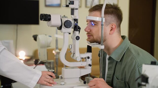 Young man undergoing eye examination with slit lamp