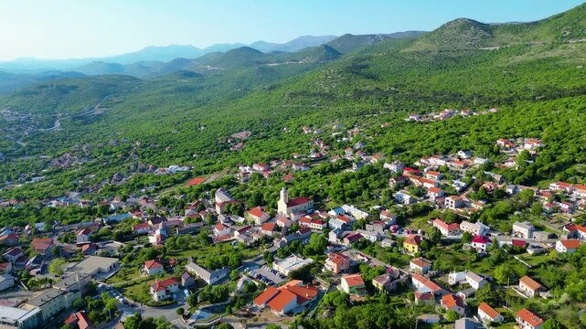 A charming Croatian Hreljin village nestled amidst lush green hills under a clear sky. Capturing the serene beauty of the Kvarner region's inland landscape.