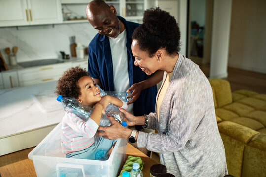 Parents and child recycling plastic in a home kitchen