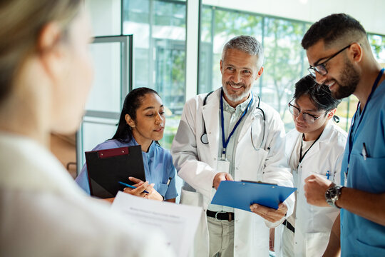 Doctors and nurses discussing patient rounds in hospital