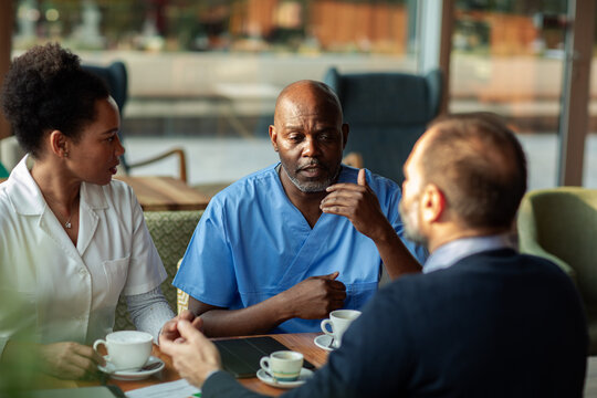 Healthcare workers collaborating over coffee in hospital cafeteria