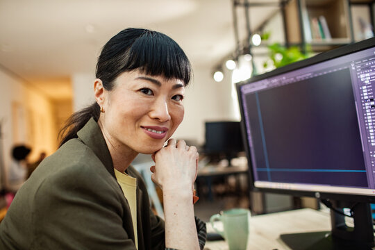 Smiling designer working at computer in modern office