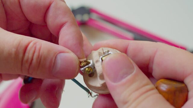 POV macro shot of hands restoring desk lamp. A first-person perspective video with shallow depth of field showing a craftsman 
