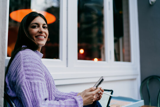 Young woman looking up with smile while working on tablet with electronic pen. Ambition, career goals, and digital transformation. Female expert using modern software for business task, remote life.