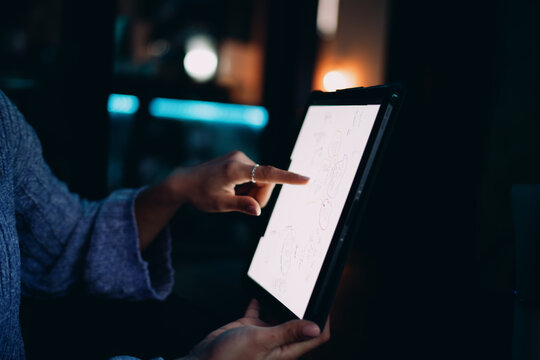 Professional woman using tablet device in modern office corridor with wooden walls. Digital nomad browsing online, creative designer working remotely, modern IT business concept, wireless connection.