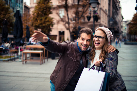Young couple shopping and sightseeing on an autumn city street