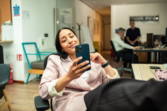 Young businesswoman using smartphone during break in modern office