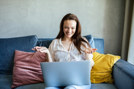 Smiling woman on video call using laptop at home