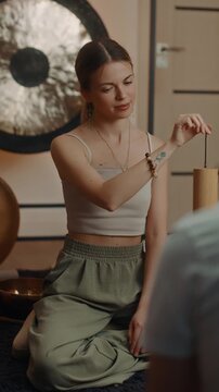 Woman using pendulum during meditation and sound healing session