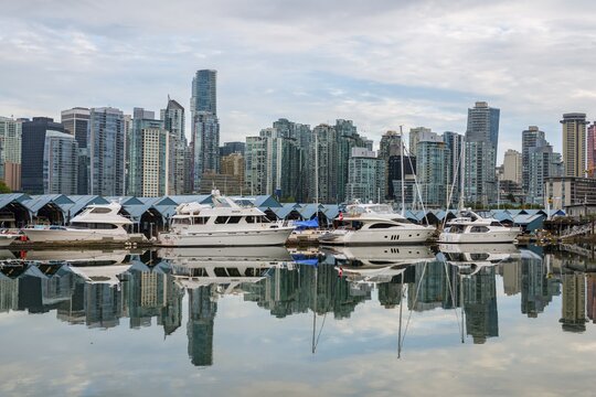 Skyscrapers and sailboats in the marina, skyline of Vancouver reflected in the sea, Coal Harbour, Downton Vancouver, British Columbia, Canada