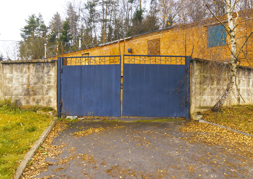 Hidden entrance with vivid contrast. Concealed compound entry with textured surfaces and autumn decor