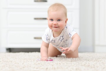 Fototapeta premium Cute little baby with toy crawling on floor at home