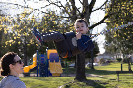 Happy Toddler On Swing At Sunny Playground With Parent Pushing In Burnaby Vancouver BC Canada