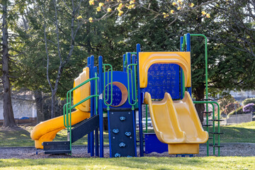 Fototapeta premium Colorful Children's Playground With Yellow Slides and Climbing Playset in Burnaby Park, Vancouver BC Canada