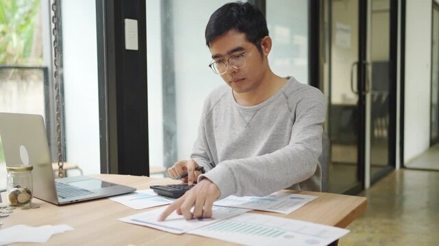 Financial planning and budgeting are essential for individuals and businesses. This shows a person using a calculator and analyzing various business reports and charts on a desk.