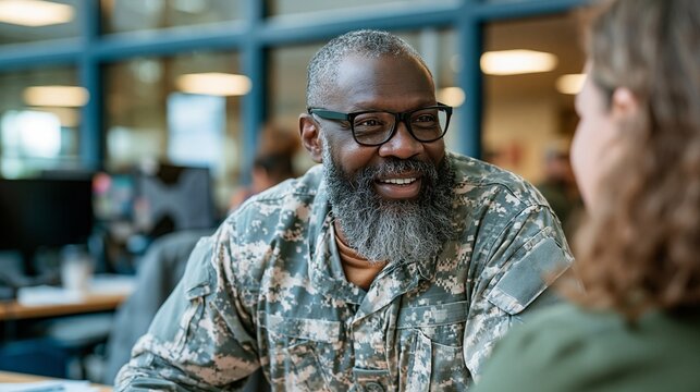 Medium shot of a diverse older veteran attentively discussing ergonomic desk accommodations with an employment specialist in a bright disability resource center soft daylight