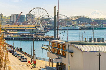 The downtown waterfront district of Seattle, Washington, with the Great Wheel, Pier 57, sports stadiums, and Mount Rainier in view. © Kirk Fisher