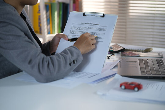 a car salesperson is explaining the details of a car purchase contract to the buyer before signing the sales contract, showroom, dealer, car contract, sining a car purchase contract

