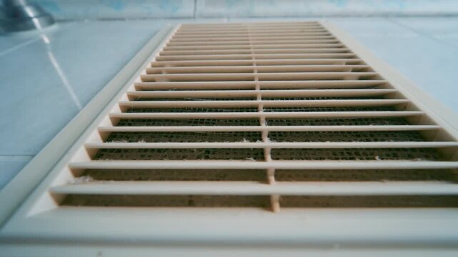 Dirty Clogged Ventilation Grille on Bathroom Wall | Wide-Angle Low-Angle Close-Up | HVAC Maintenance, Air Quality and Home Service Concept