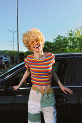 Cheerful woman outdoors, laughing with eyes closed, sunlit moment, relaxed pose, soft breeze,...