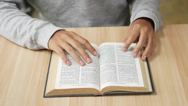 Faith-based footage of a person reading the Bible and praying in a quiet moment of devotion, reflection, and contemplation.