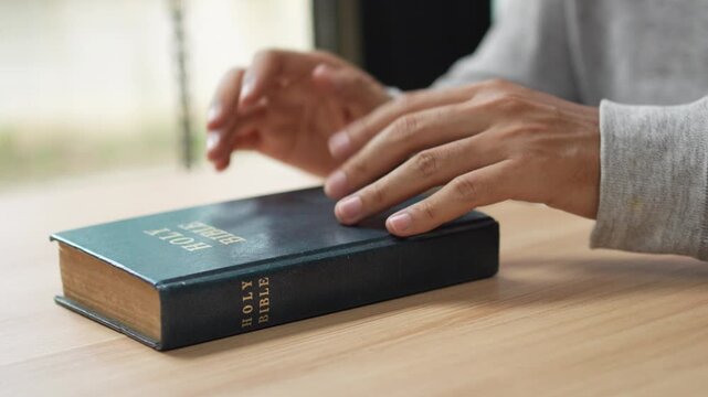 A person praying and reading the Bible for spiritual reflection and devotion.