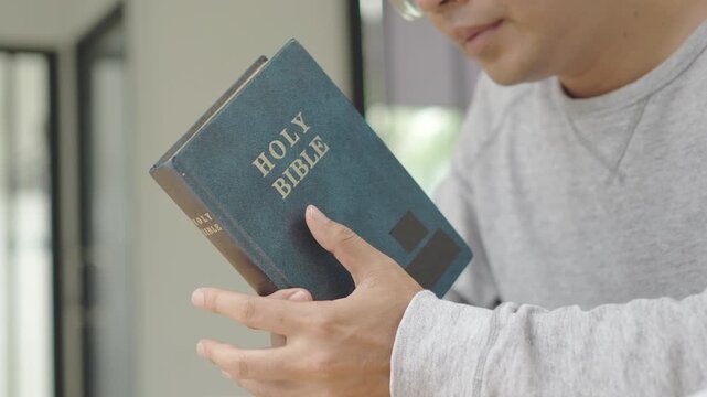 Person praying with a Holy Bible, expressing faith and spiritual reflection.