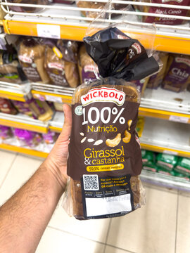 BELO HORIZONTE, MG, BRAZIL, MAY, 10, 2026 A hand holding a package of Wickbold 100% Nutricao Girassol & castanha bread in a grocery store aisle