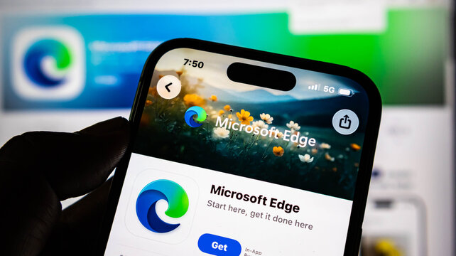 Closeup of a smartphone screen displaying the microsoft edge app store page, held in a hand with a blurred background