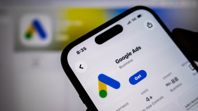 Closeup of a smartphone screen displaying the google ads app store page, showing the application icon, download button, and ranking information
