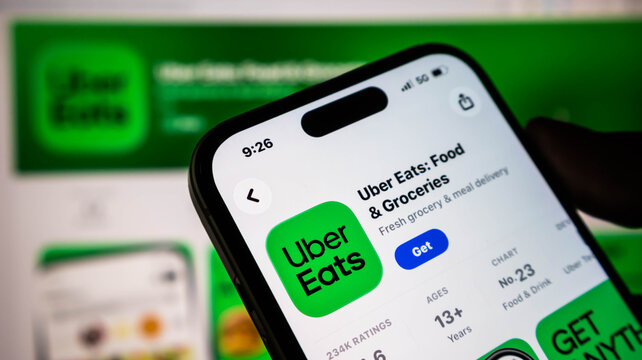 Closeup of a smartphone screen displaying the uber eats app store page for downloading food and grocery delivery services