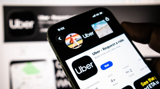 Closeup of a smartphone screen displaying the uber app store page, showing the application icon, download button, and app details