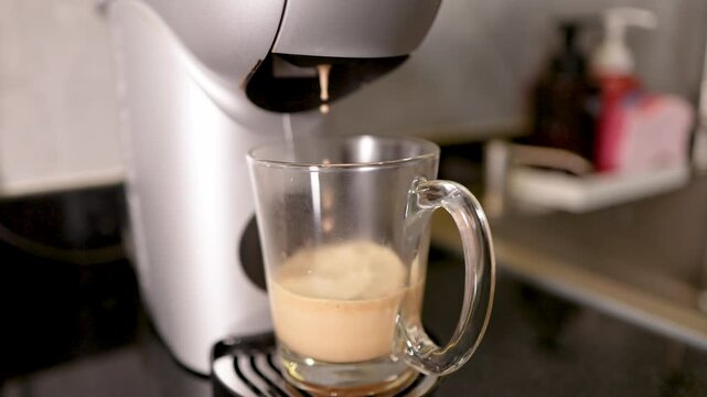 Automatic Coffee Machine Pouring Fresh Latte Into Glass Mug on Counter
