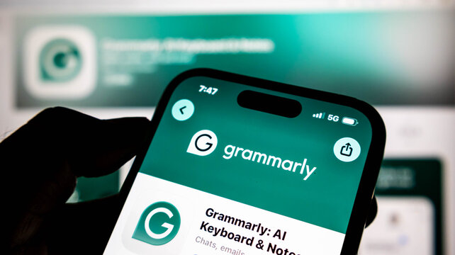 Closeup of a smartphone screen displaying the grammarly app store page, showing the logo and app name against a blurred background