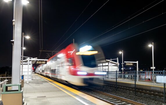 Motion-blurred San Jose - San Francisco commuter train arriving at San Bruno station in the Bay Area, California, United States
